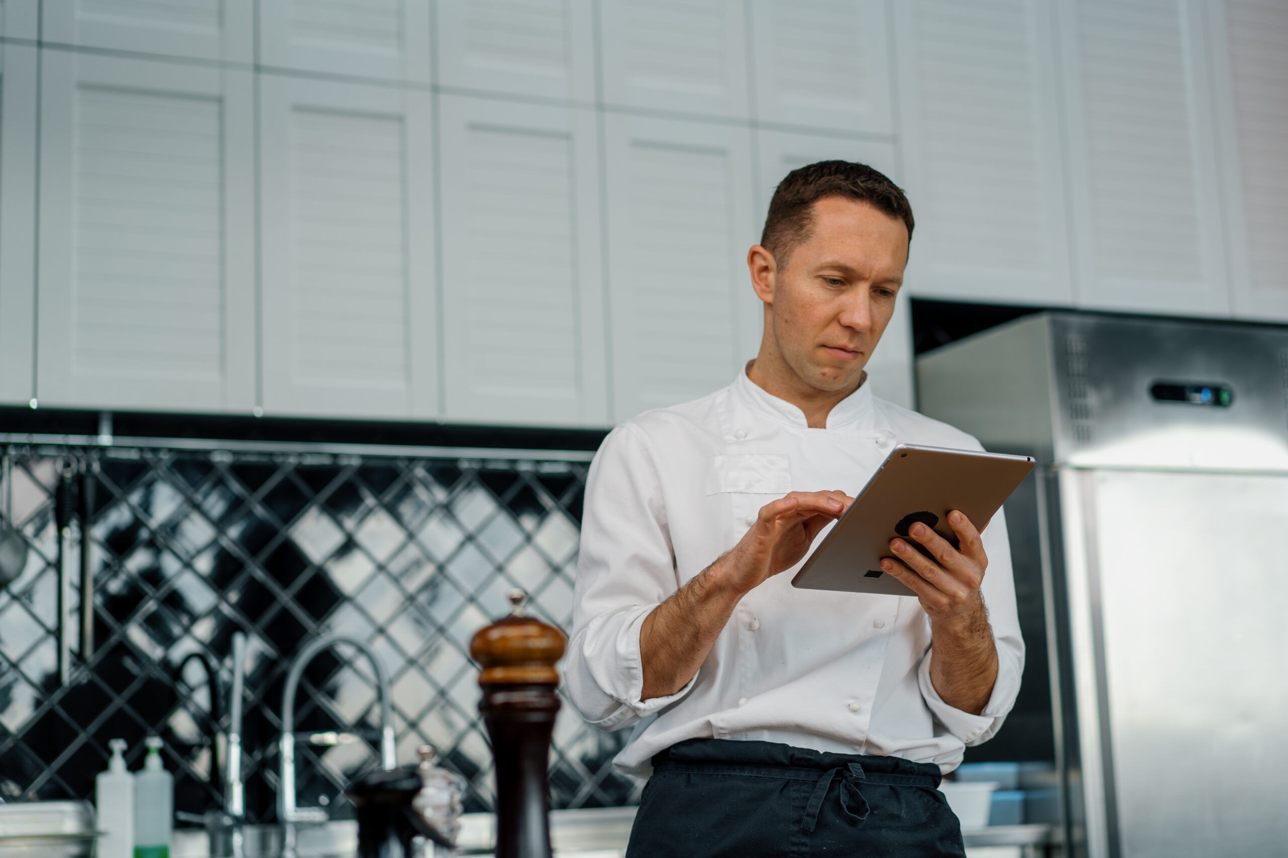 A restaurant manager reviewing customer feedback on a tablet to improve menu and brand changes.